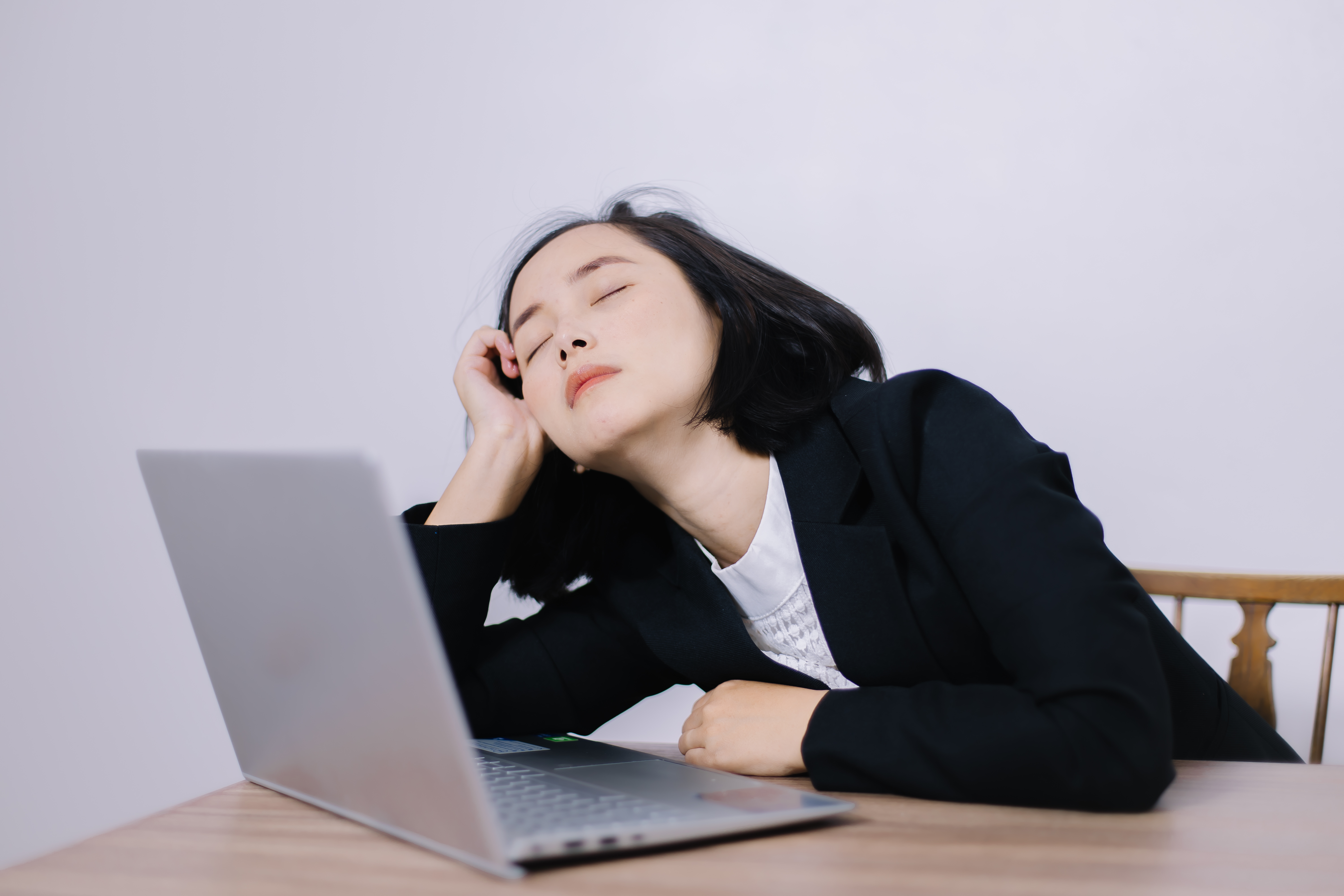 Office worker at desk struggling with brain fog and inability to focus on laptop.